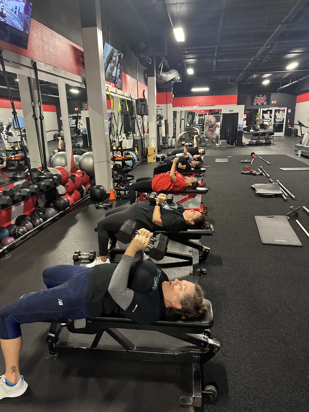 Members doing bench press during bootcamp class